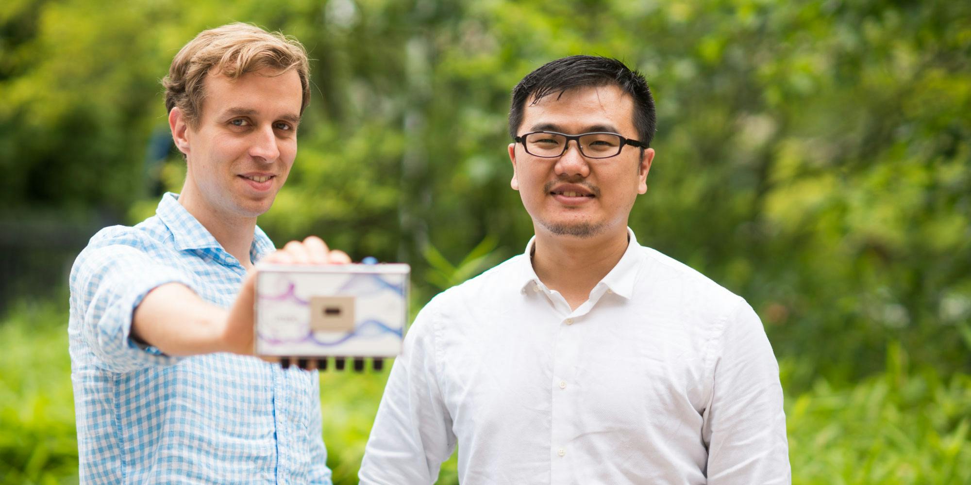 Pawel Malinowski and TungHuei Ke from imec, holding a test device used for investigating high resolution patterning of OLEDs.